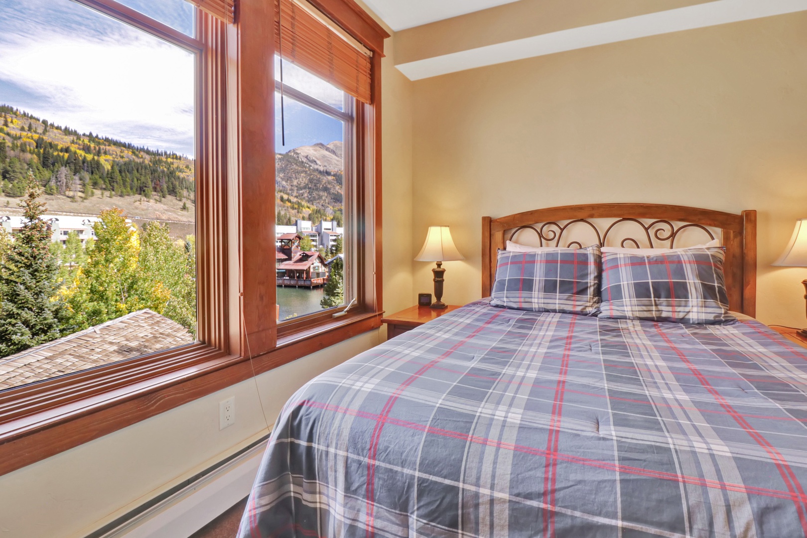 Wake up to breathtaking mountain and lake vistas framed by warm wood trim. Your cozy plaid bedding sets a relaxed alpine tone for a peaceful retreat.