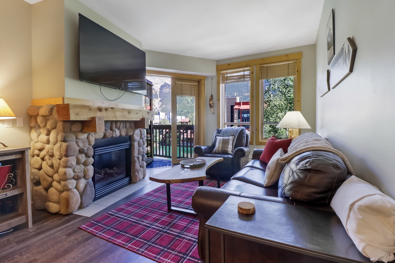 Sink into plush leather seating by your stone fireplace and soak in mountain views through expansive windows—your cozy alpine retreat awaits.