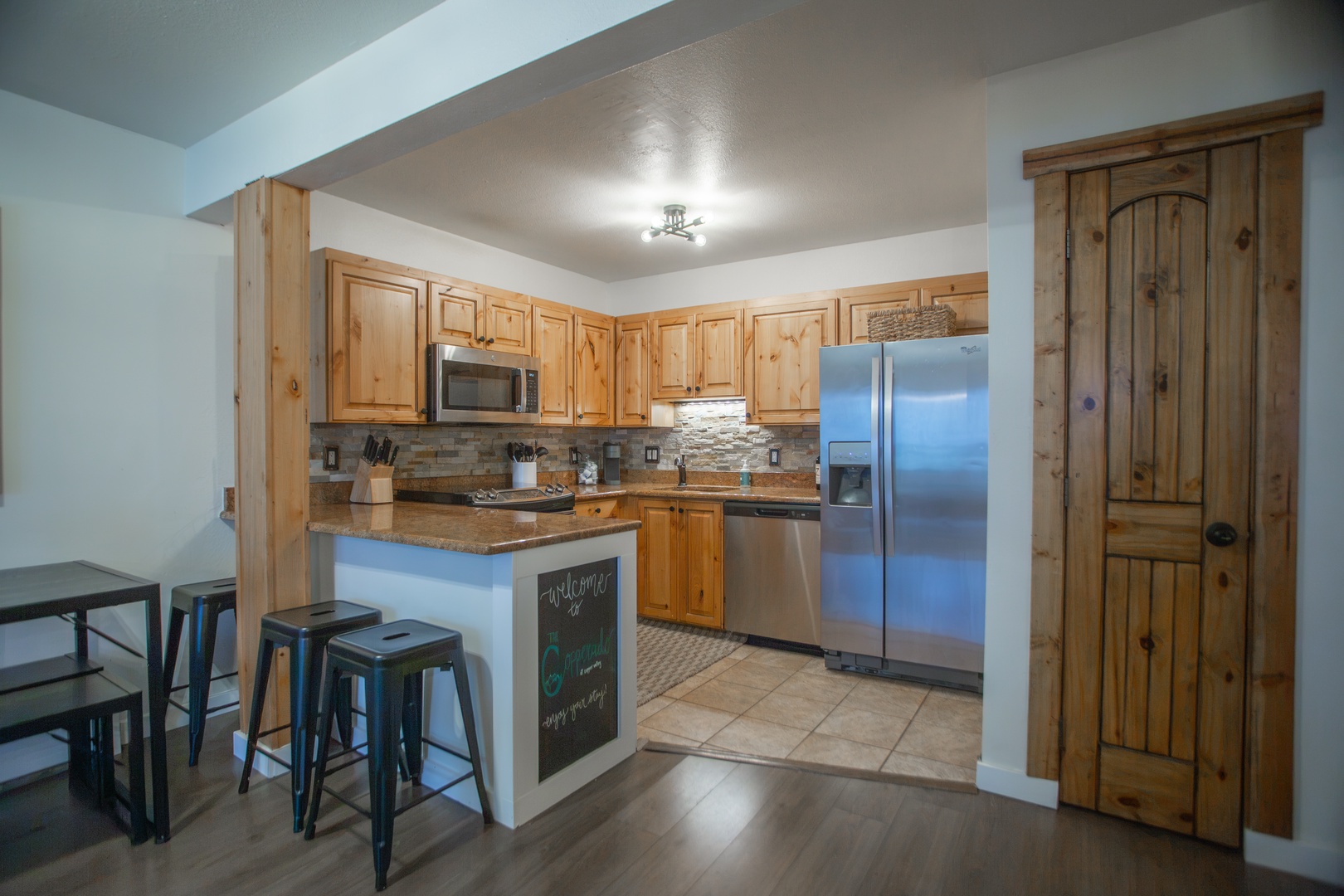 Your fully equipped kitchen features warm wood cabinetry, stainless steel appliances, and a breakfast bar—perfect for whipping up morning coffee or sharing meals together.