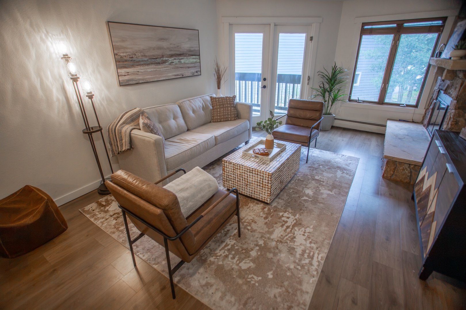 Sink into the comfort of this inviting living room, where warm natural light streams through glass doors to your private balcony. Thoughtfully styled with cozy seating and coastal tones, it's the perfect retreat for unwinding.