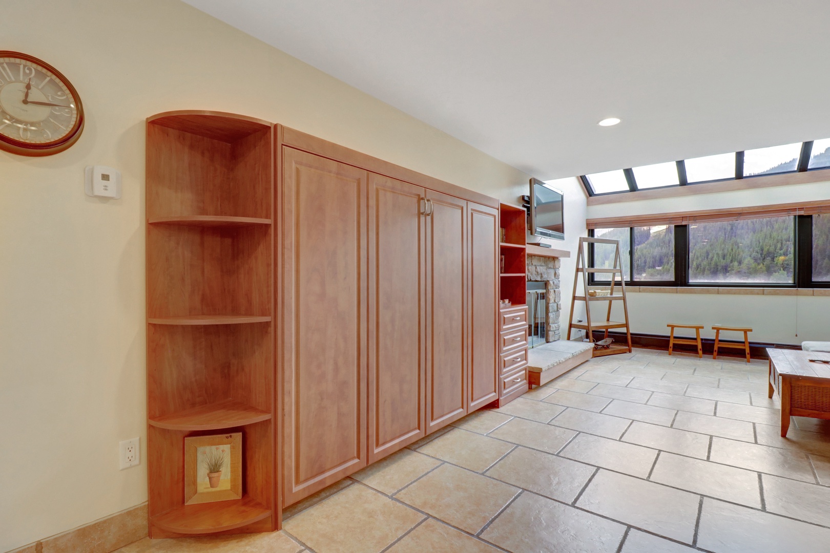 Spacious living area featuring a built-in Murphy bed concealed in elegant wood cabinetry, providing flexible sleeping arrangements without sacrificing floor space.