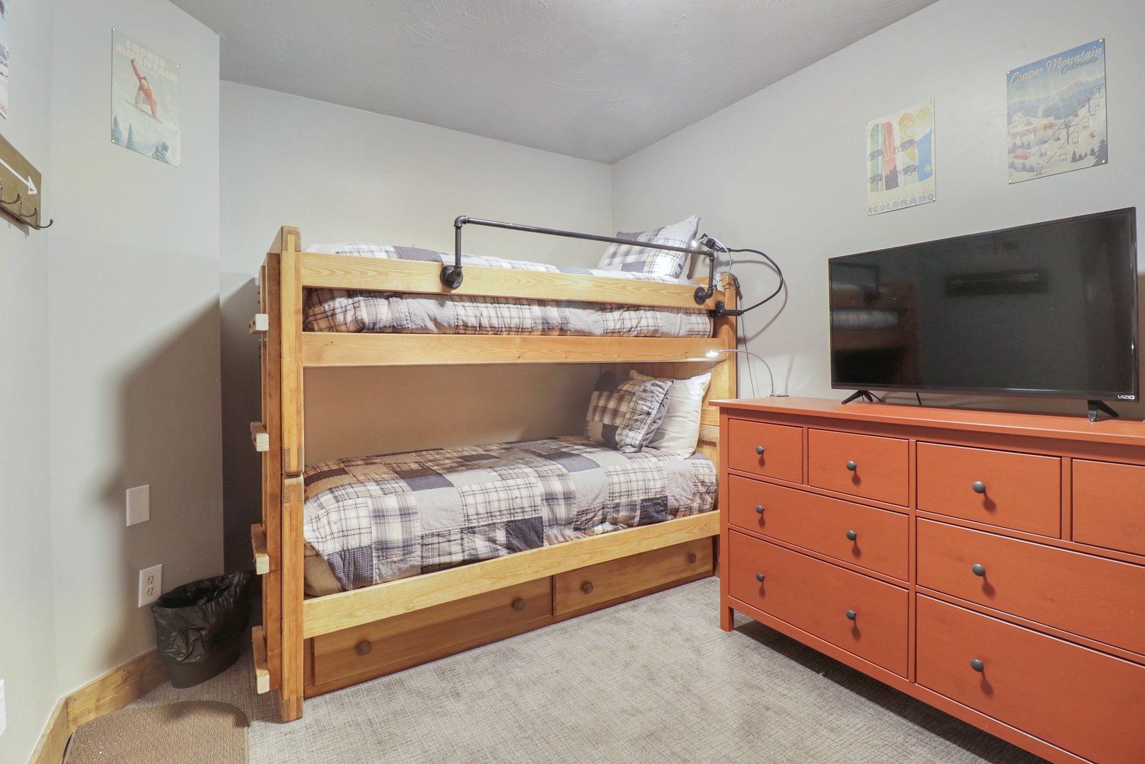Your cozy bedroom features comfortable bunk beds with soft plaid linens, perfect for family stays. Enjoy entertainment on the flat-screen TV while kids have their own space to rest and play.