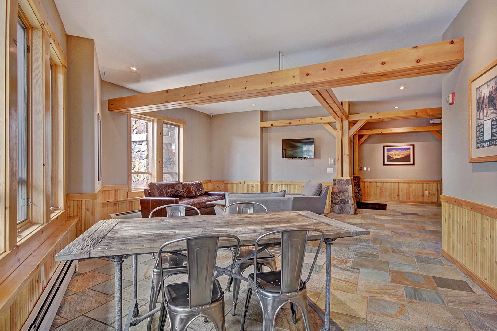 Gather around a handcrafted live-edge wood table in this spacious open-concept living and dining area. Warm timber beams and mountain sunshine create the perfect setting to relax and make memories.