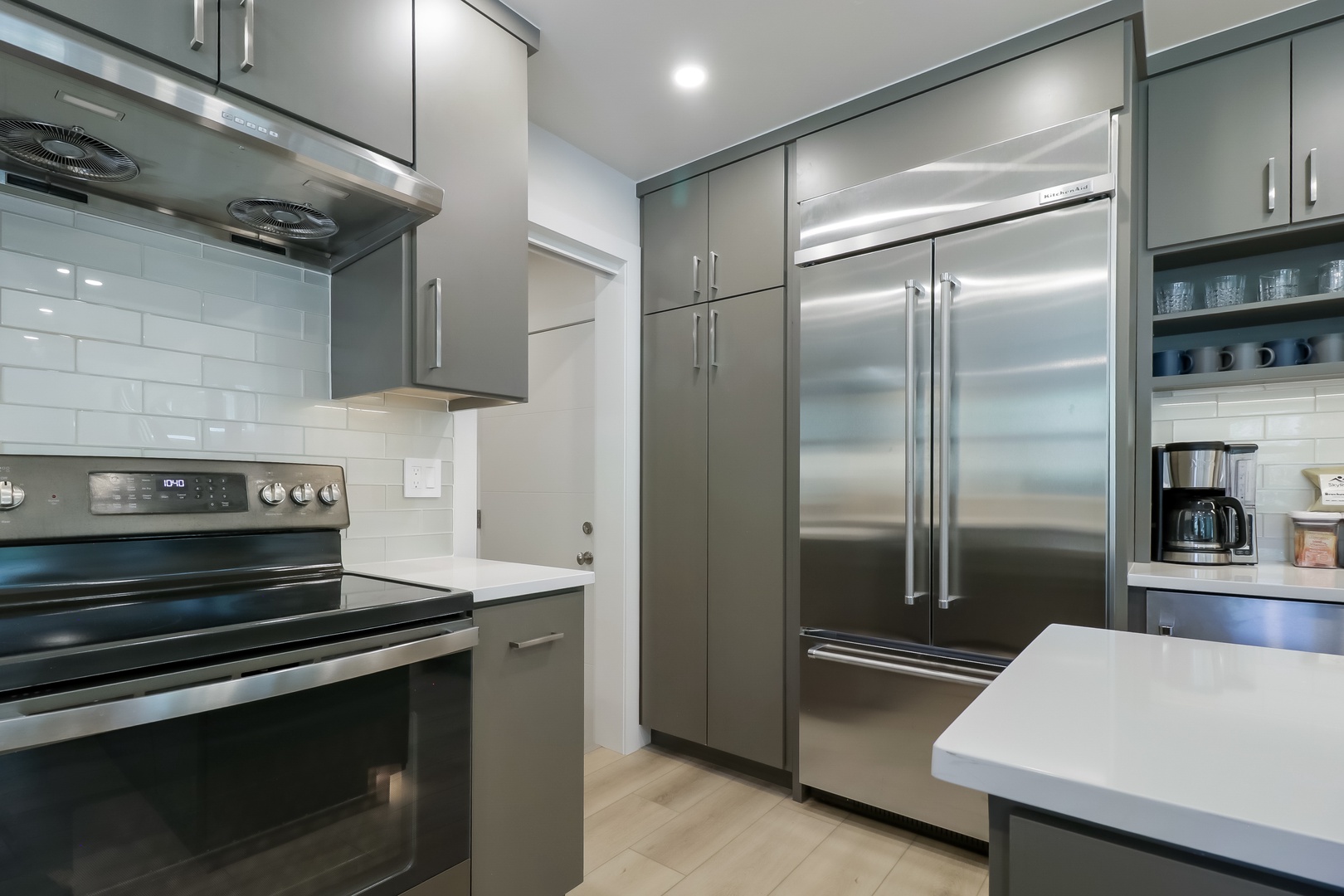 Step into your sleek modern kitchen with stainless steel appliances, pristine white counters, and soft wood floors that make meal prep a pleasure.