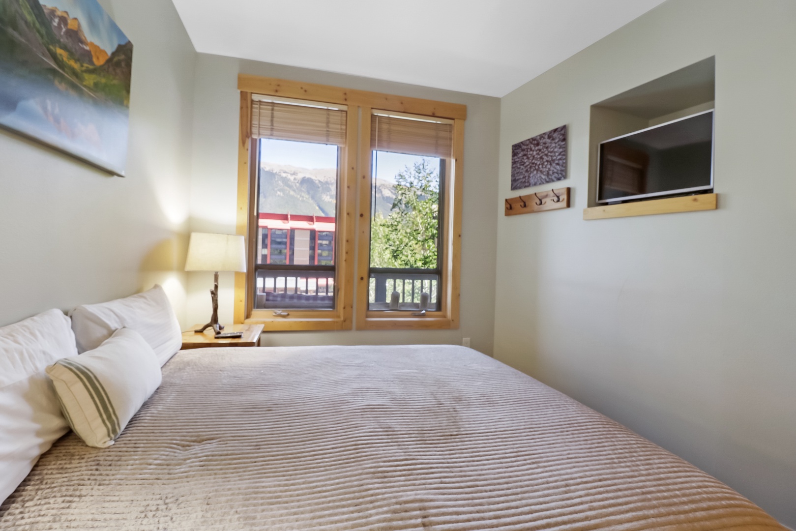 Drift off in comfort with mountain views framing your morning wake-up. Natural light fills your cozy bedroom retreat, complete with a wall-mounted TV for relaxing evenings in.