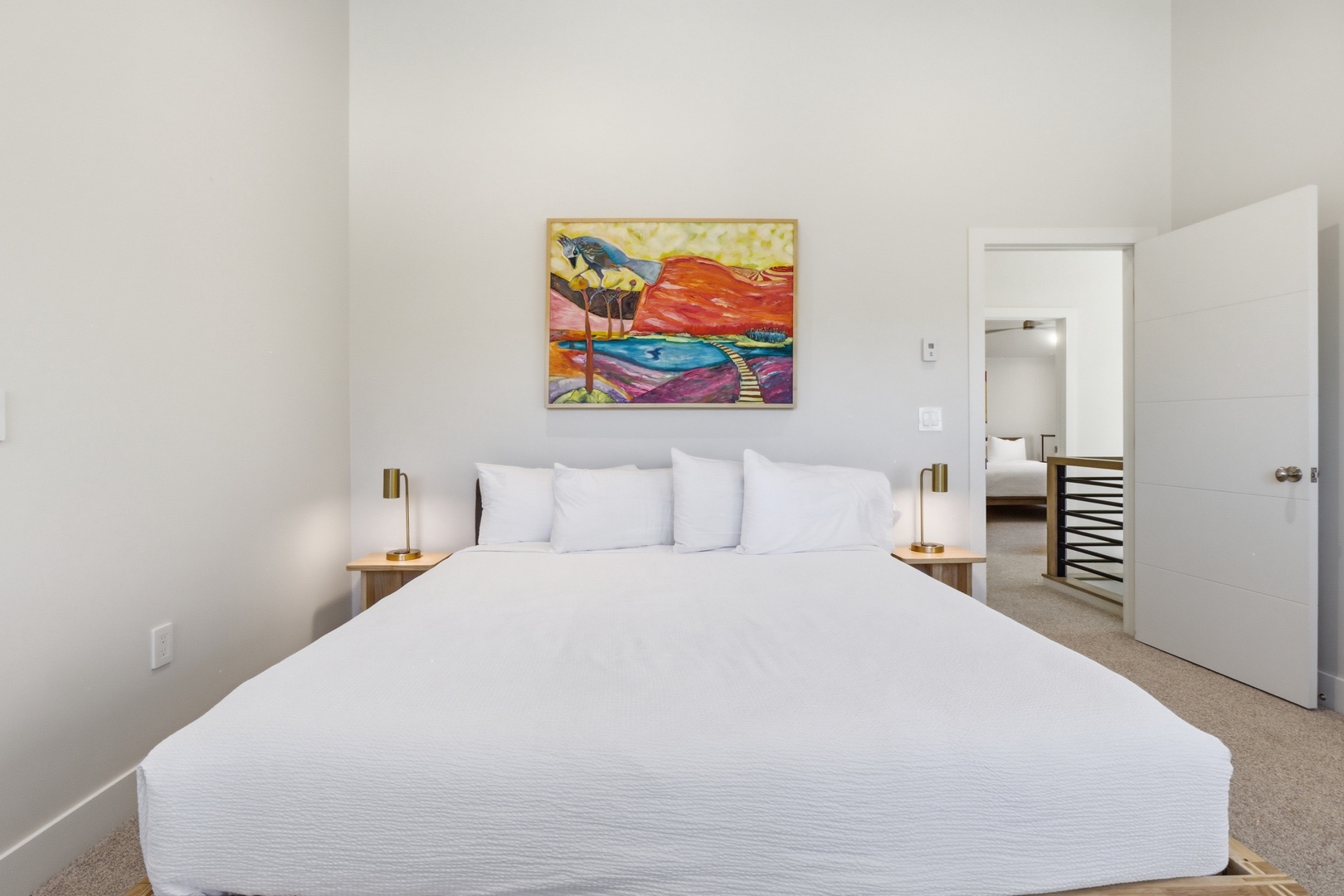 Sink into crisp linens and peaceful comfort in your serene sleeping space, where vibrant artwork and modern touches create the perfect retreat for restful nights.