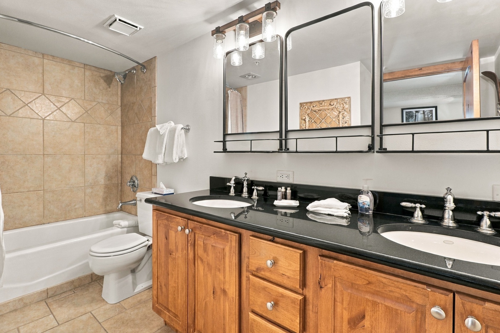 Your private bathroom features a tiled walk-in shower, elegant dual vanities with gleaming countertops, and all the fresh towels you'll need to unwind after a day exploring.