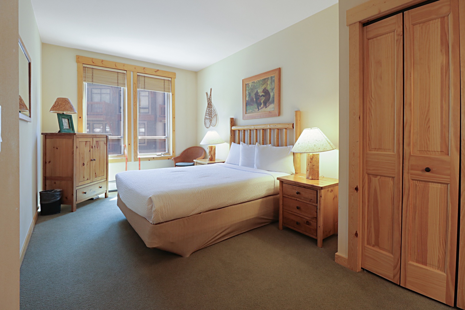 Drift into peaceful sleep on your comfortable queen bed, surrounded by warm pine furnishings and soft lighting in this cozy retreat.