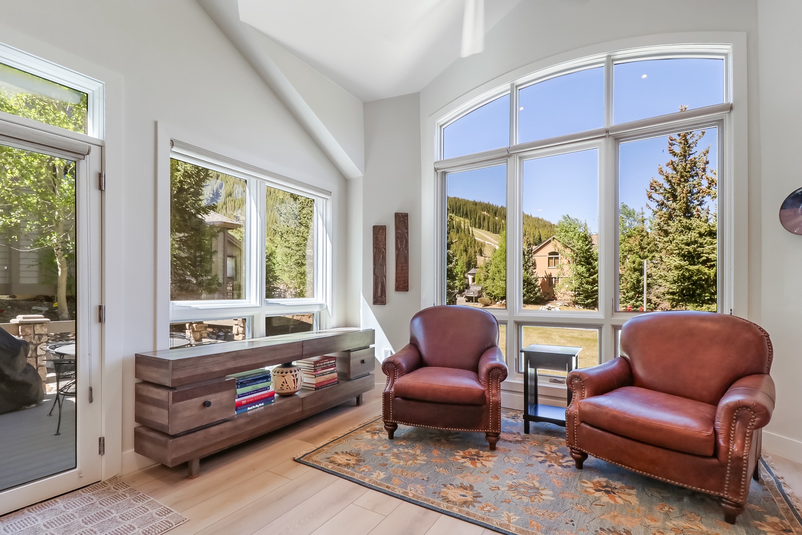 Sink into plush leather armchairs as natural light pours through soaring windows, framing mountain views and lush pine trees that invite you to unwind completely.