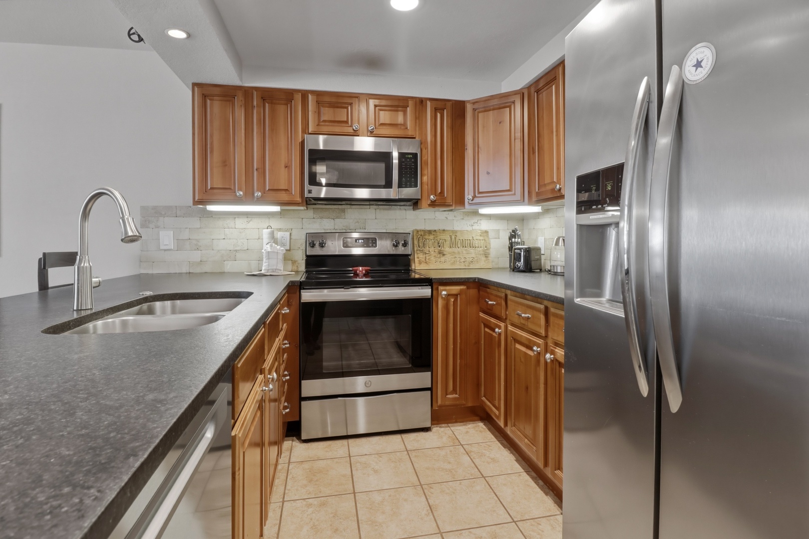 Cook your favorite meals in this fully equipped kitchen with stainless appliances, granite counters, and warm wood cabinets.