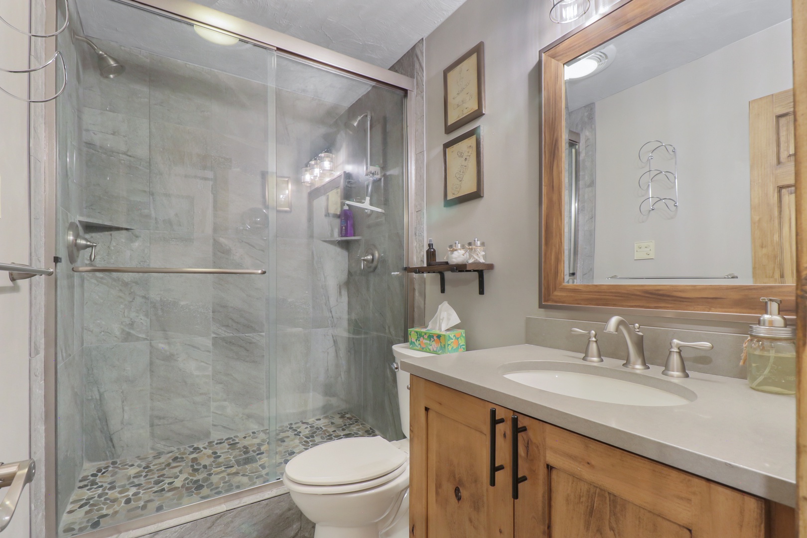 Pamper yourself in this beautifully appointed bathroom featuring a spacious walk-in shower with elegant marble-look tiles and a stylish wood vanity where you can start and end each day feeling refreshed.