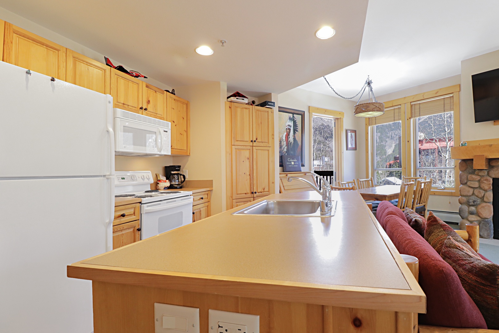 Your fully equipped kitchen island beckons with warm wood cabinets and modern appliances, perfect for preparing meals together.