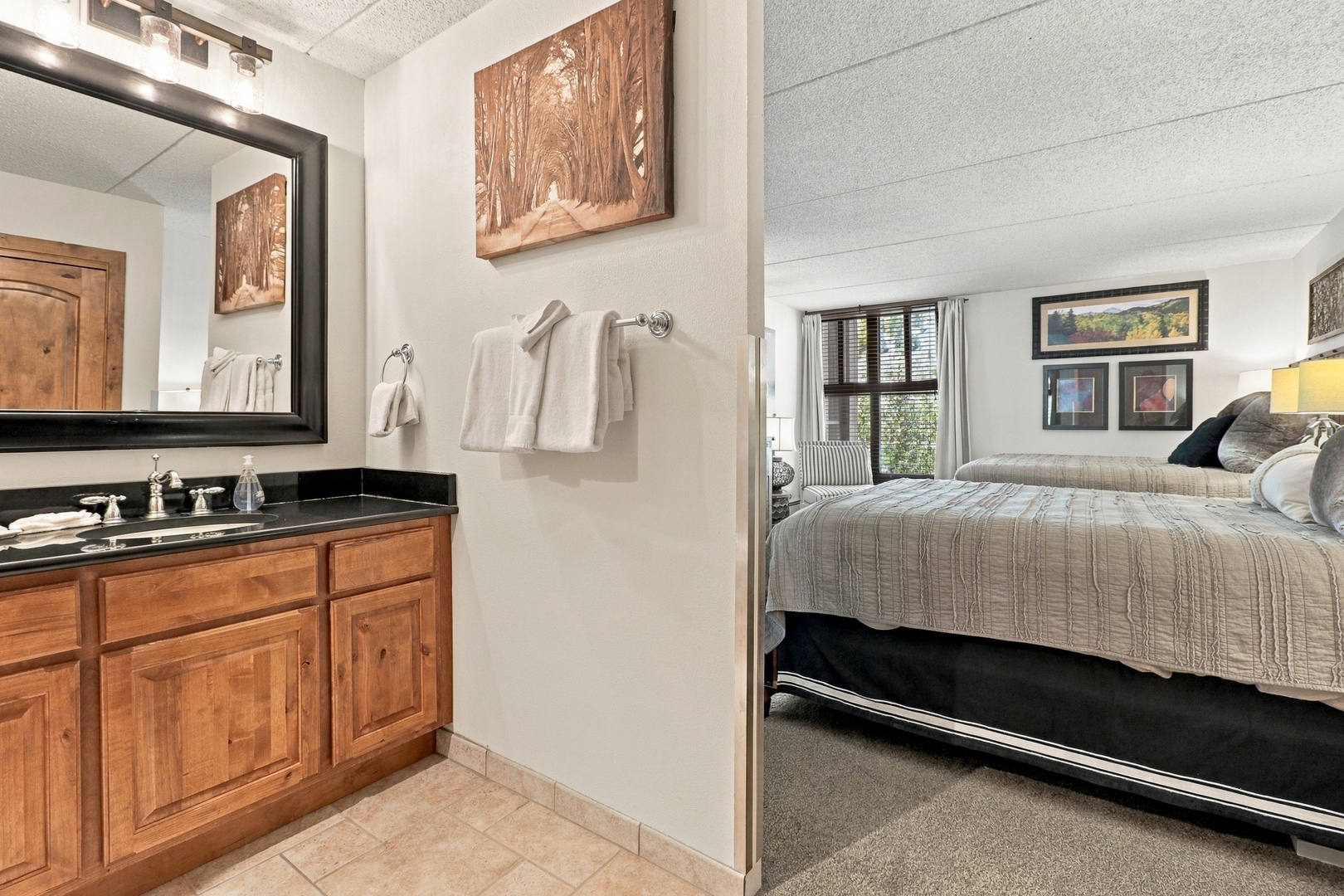 You'll find fresh towels and a vanity area steps from your cozy bedroom, where warm wood tones and mountain-inspired art create a peaceful alpine retreat after a day of adventure.
