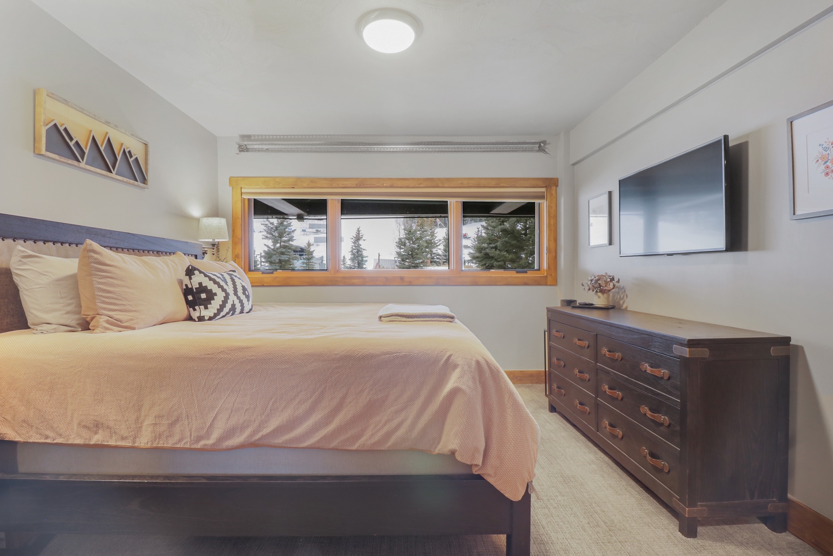 Your peaceful bedroom sanctuary awaits with crisp linens and warm mountain views. Wake up to natural light streaming through your windows as you watch the trees sway gently outside.