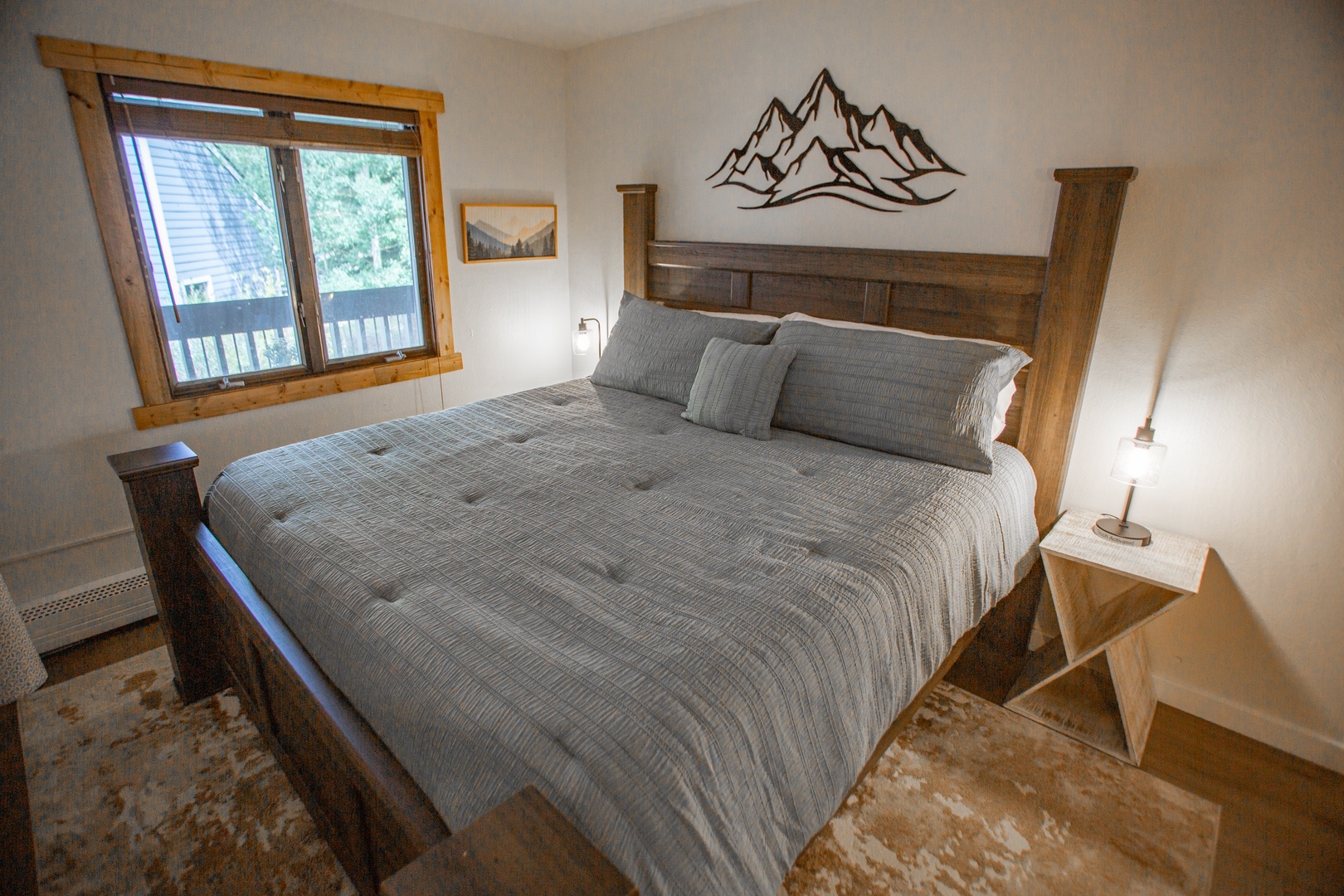 Sink into the plush bedding and wake to natural light streaming through your window, framing peaceful neighborhood views beyond the rustic wood frame.