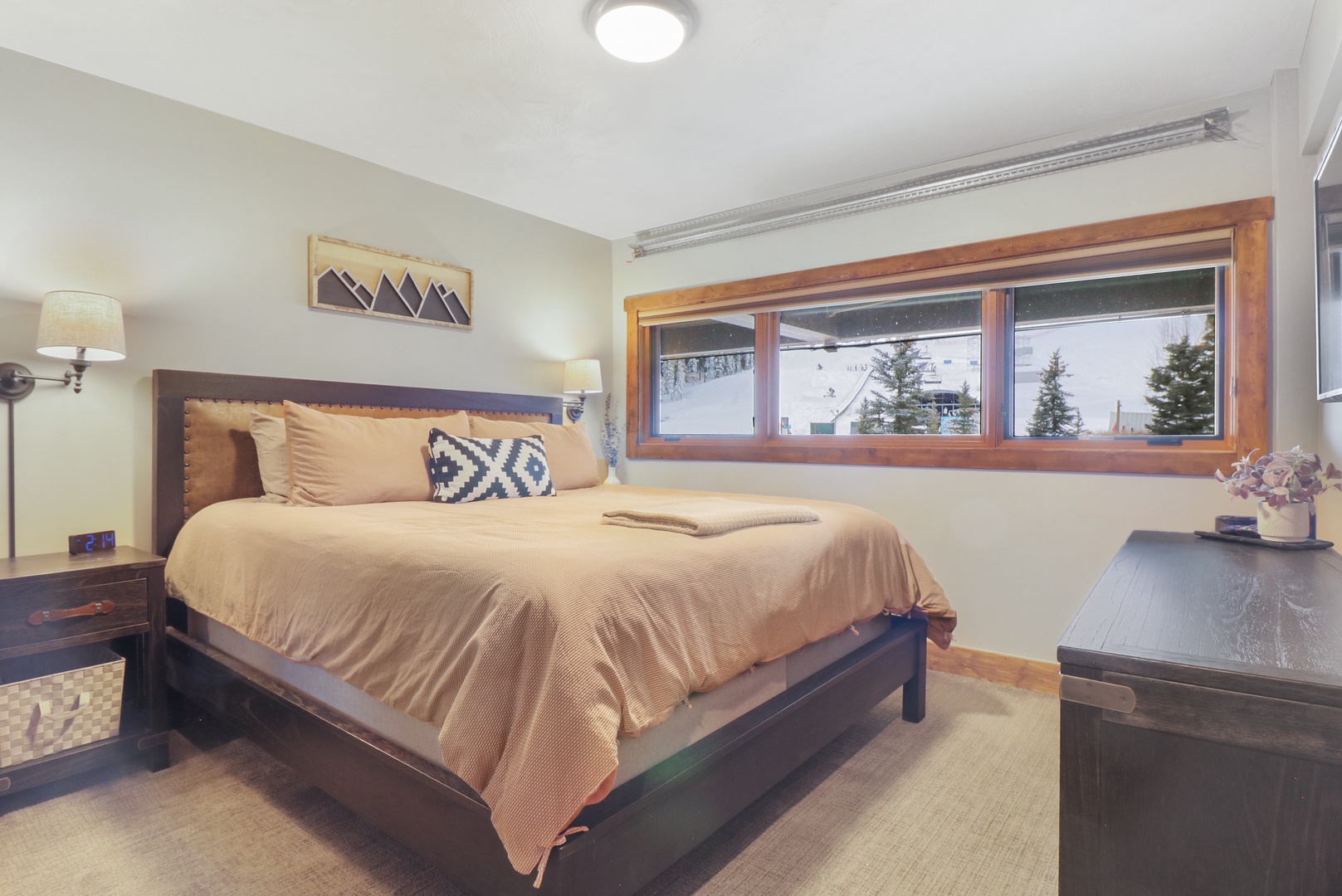 Wake up to stunning mountain views from your cozy bedroom, where warm earth tones and thoughtful touches create the perfect alpine retreat for restful nights.