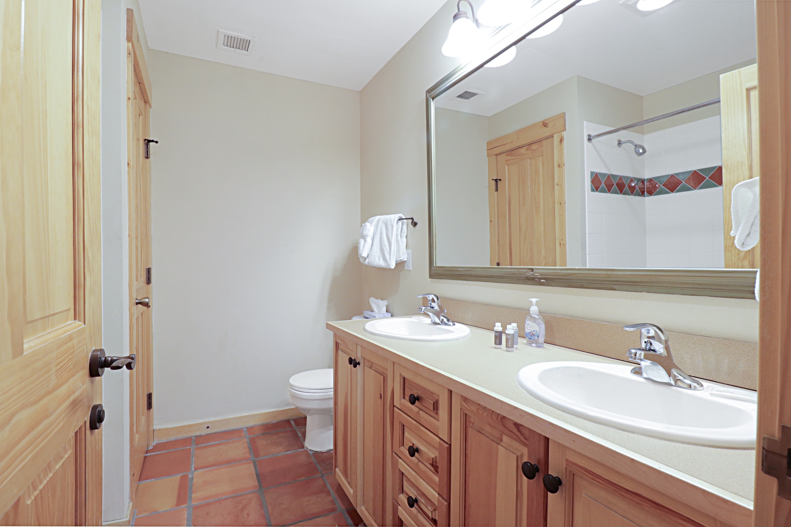 Refresh in your spacious bathroom with dual sinks, warm wood cabinetry, and thoughtful amenities that make getting ready a breeze.