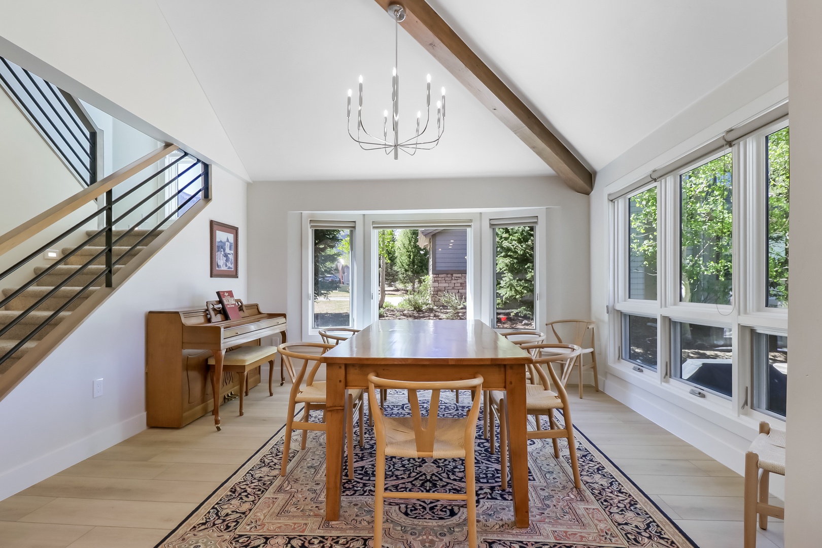 Gather around the warm wood dining table where natural light pours through expansive windows, framing garden views and creating the perfect spot for your morning coffee or evening meals together.