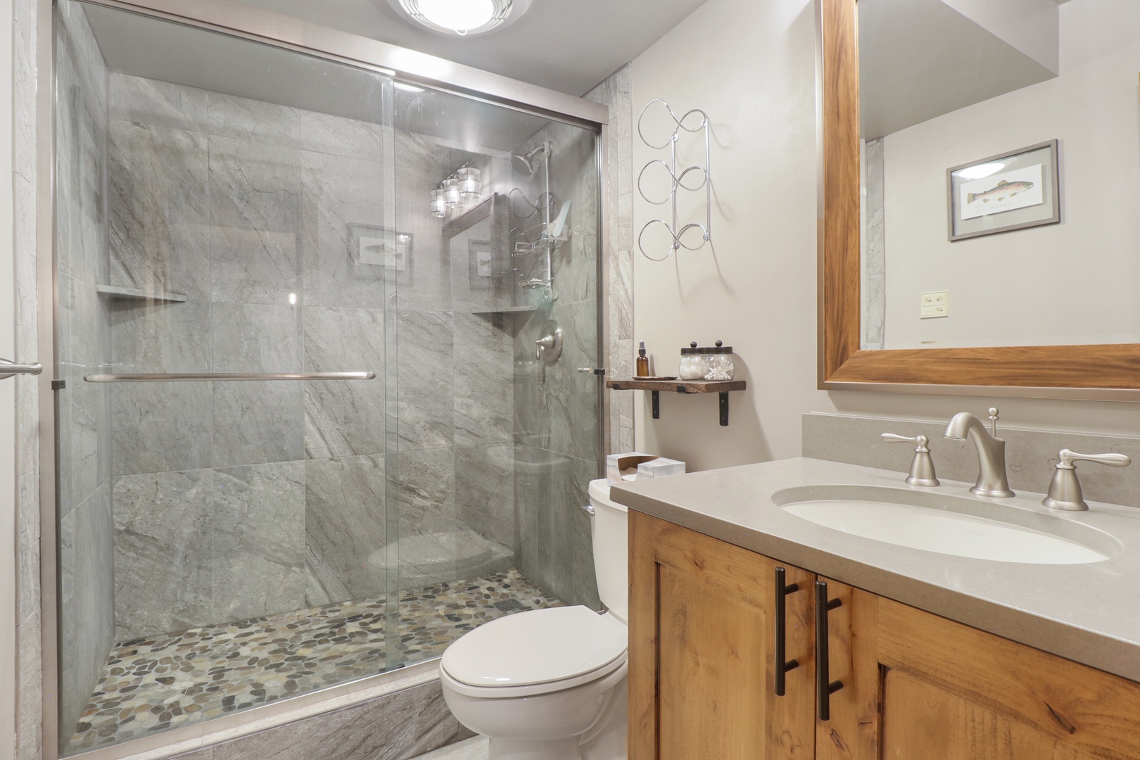 Step into your private spa-like retreat, where marble-tiled walls and a spacious glass-enclosed shower invite you to unwind after your adventures. The warm wood vanity and modern fixtures create the perfect blend of rustic charm and luxury.