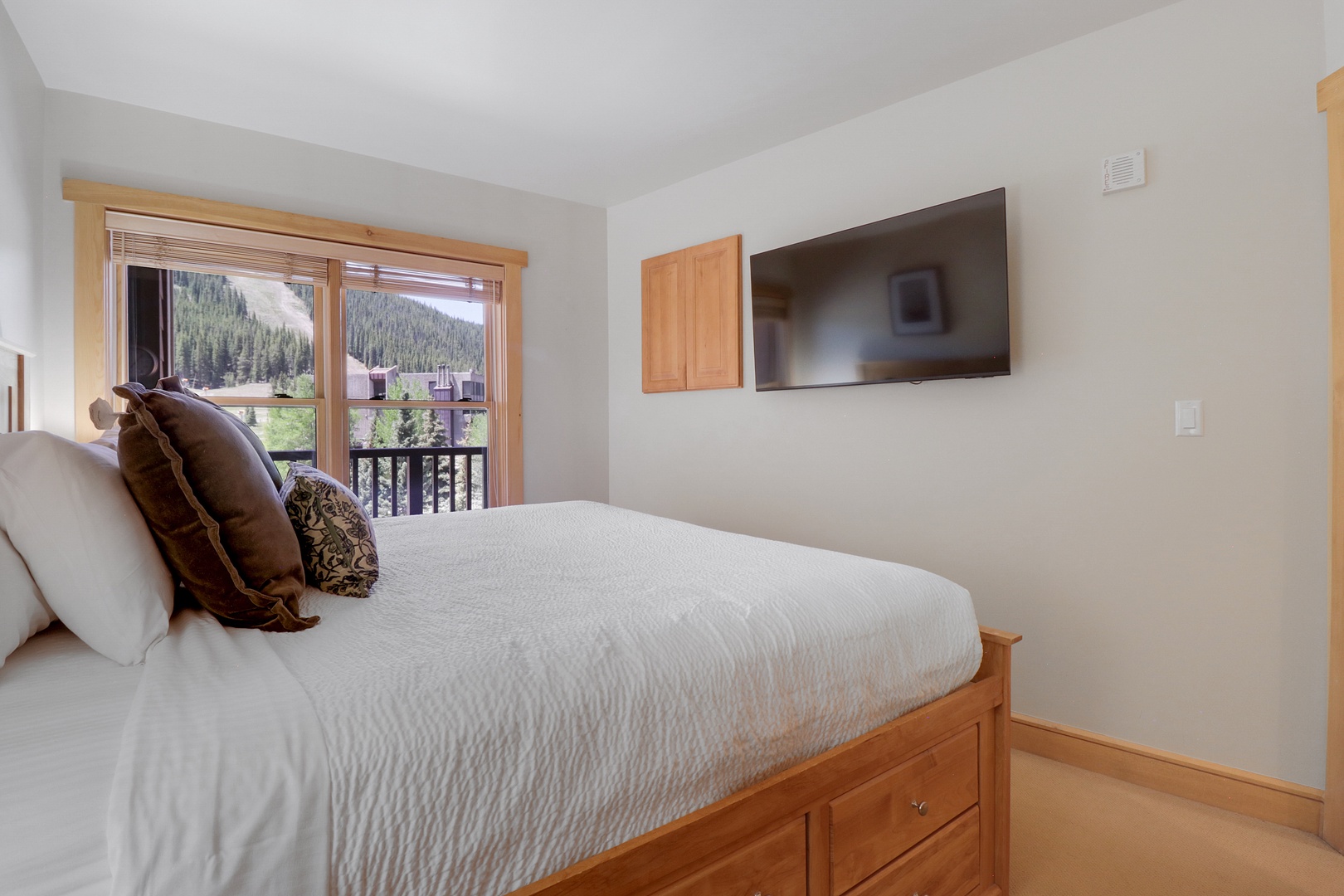 Wake up to stunning mountain views from your cozy bedroom, where crisp linens and natural light create a serene alpine retreat perfect for restful mornings.