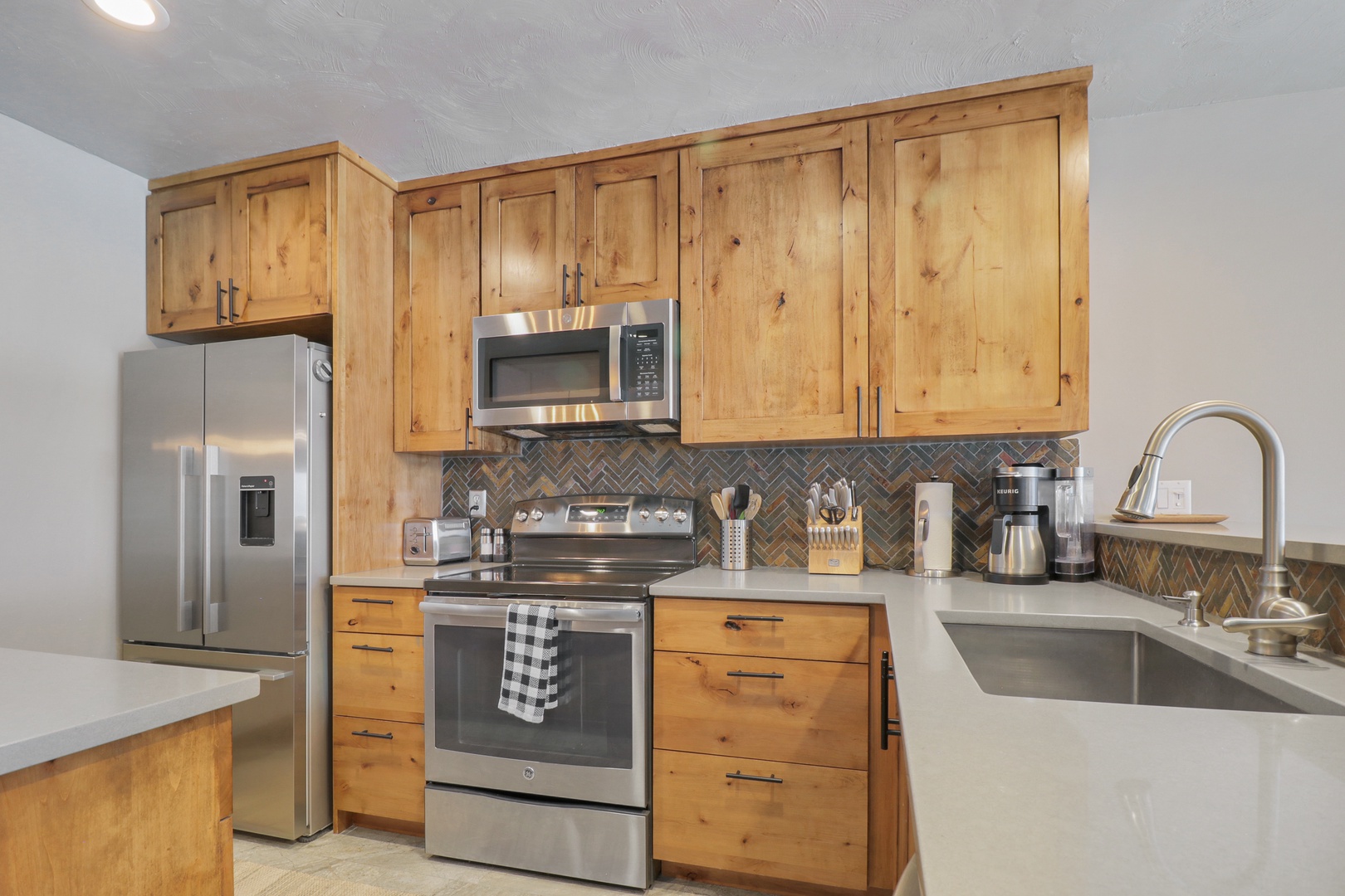 Step into your fully equipped kitchen where warm wood cabinets meet sleek stainless steel appliances. You'll love preparing meals with modern conveniences while enjoying the cozy, rustic charm.