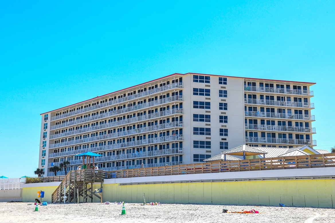 Beachfront property offering direct access to pristine white sand and crystal-clear waters under endless blue skies.