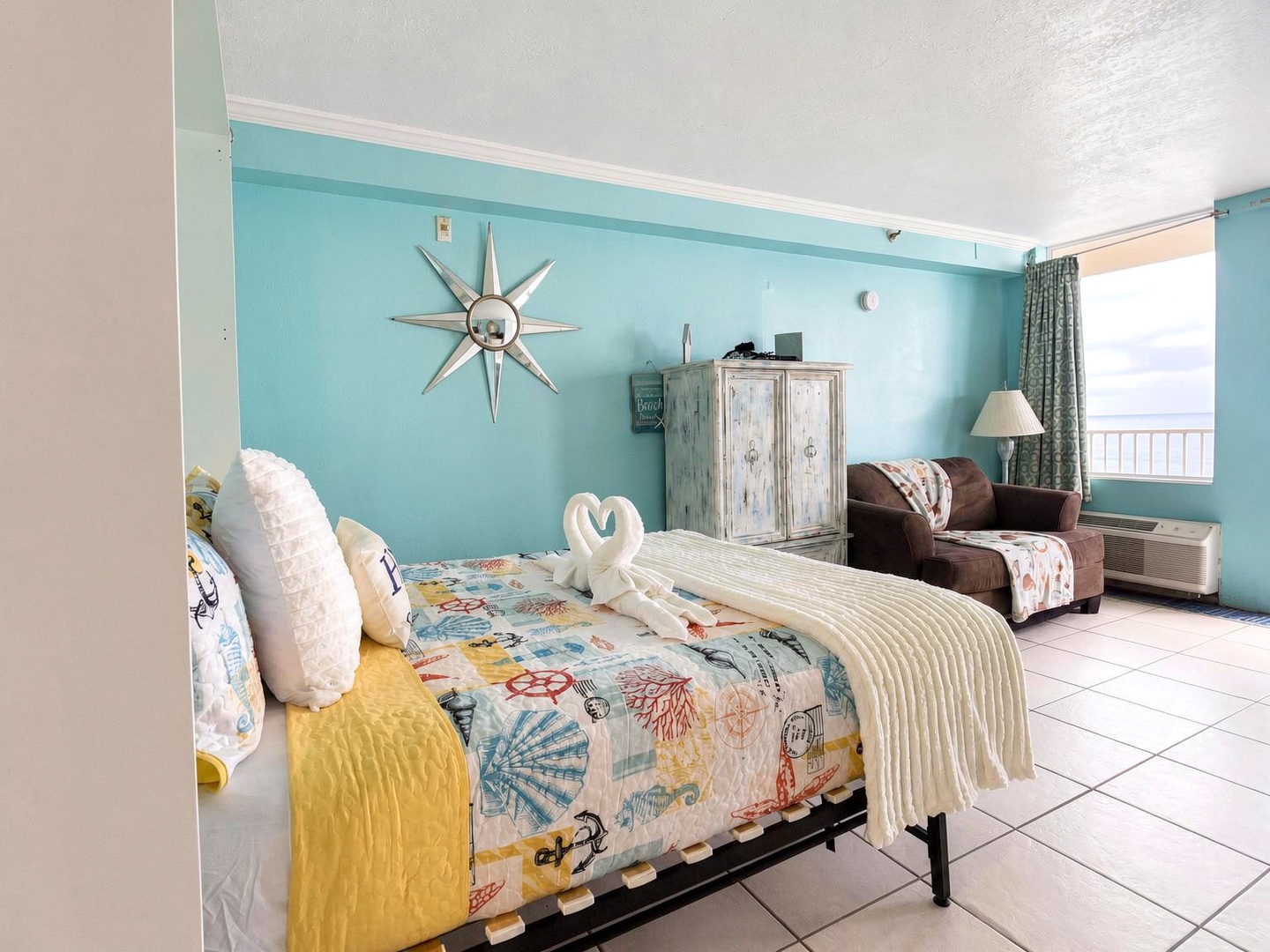 Drift off to sleep in this cheerful coastal bedroom, where soft turquoise walls and playful nautical décor set a breezy, beachy mood. Your cozy retreat features a comfy leather recliner and glimpses of the horizon through the window.