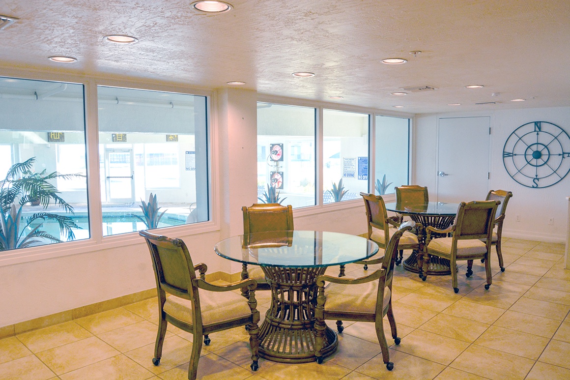 Relax in your bright communal lounge with comfortable seating areas and tropical views through floor-to-ceiling windows.