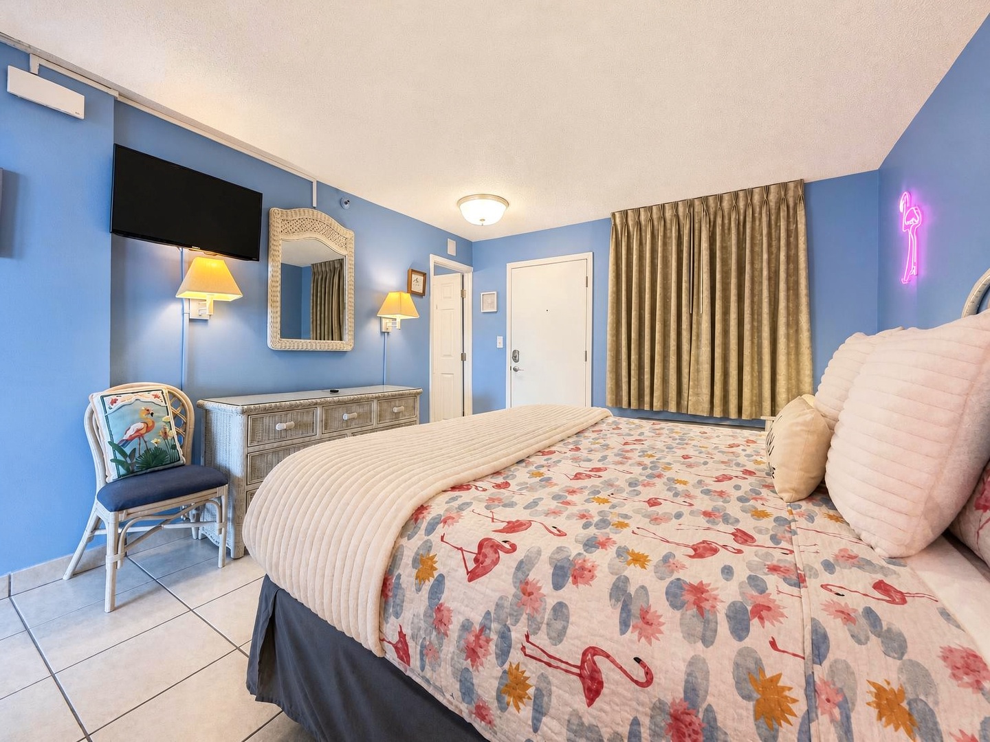Sink into soft linens and fluffy pillows after a day of exploring. Your cheerful room offers soothing blue walls, warm lighting, and quirky touches like a playful neon flamingo to make you smile.