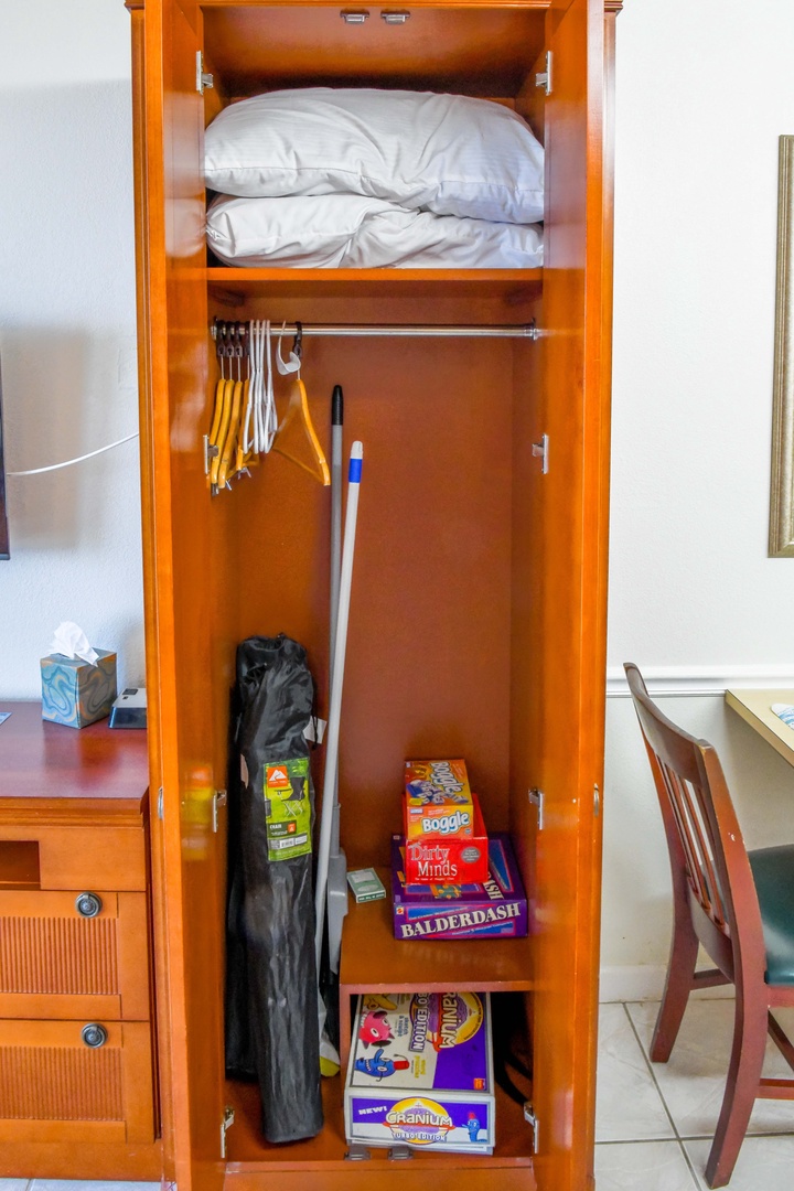 Find everything you need at your fingertips—fresh linens above, hanging space for your clothes, and even a few games to enjoy on a rainy day.