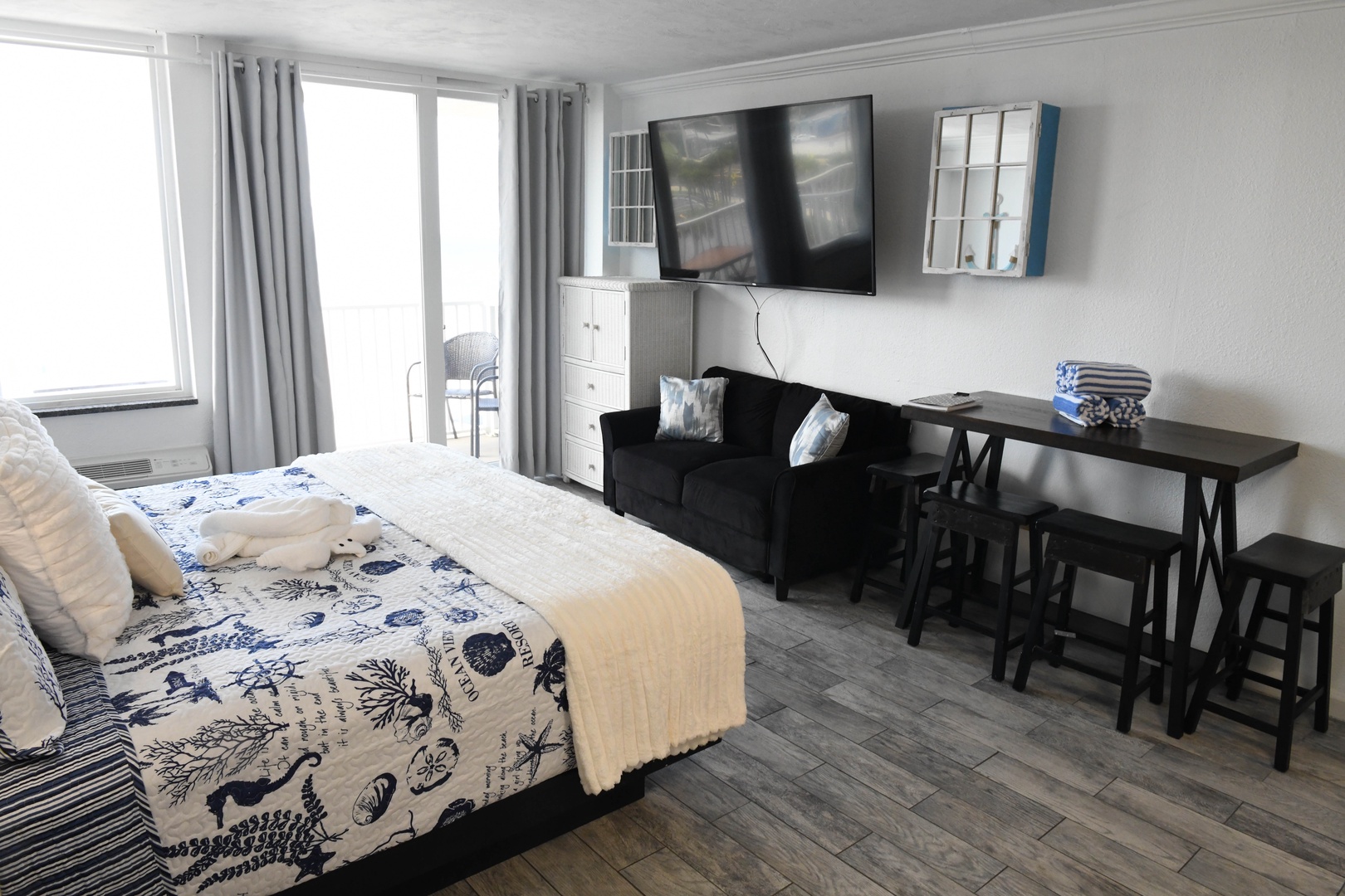 Relax in your coastal retreat with a cozy bed, lounge seating, flat-screen TV, and bright oceanfront views. Your perfect beach escape awaits.