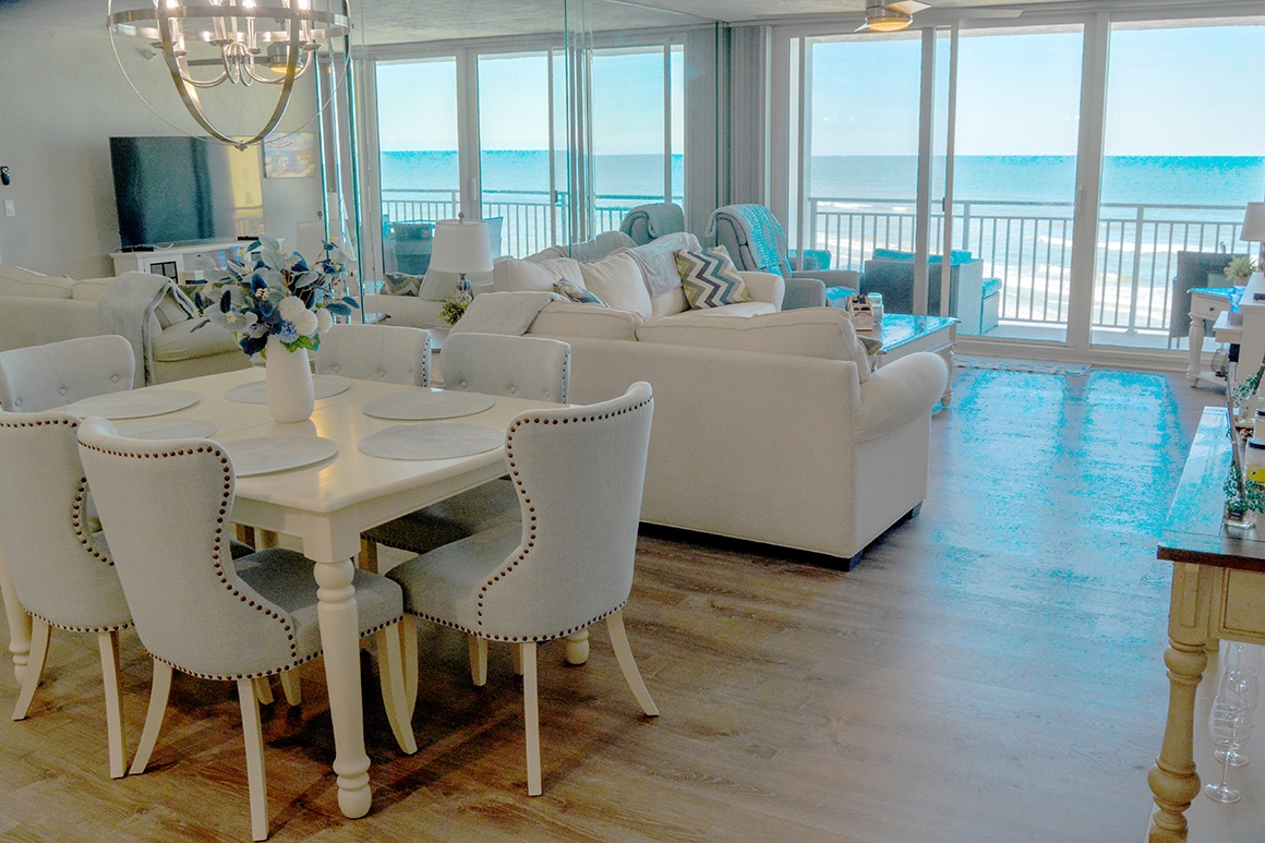 Relax in your elegant beachfront living space where turquoise waters stretch endlessly beyond floor-to-ceiling windows.