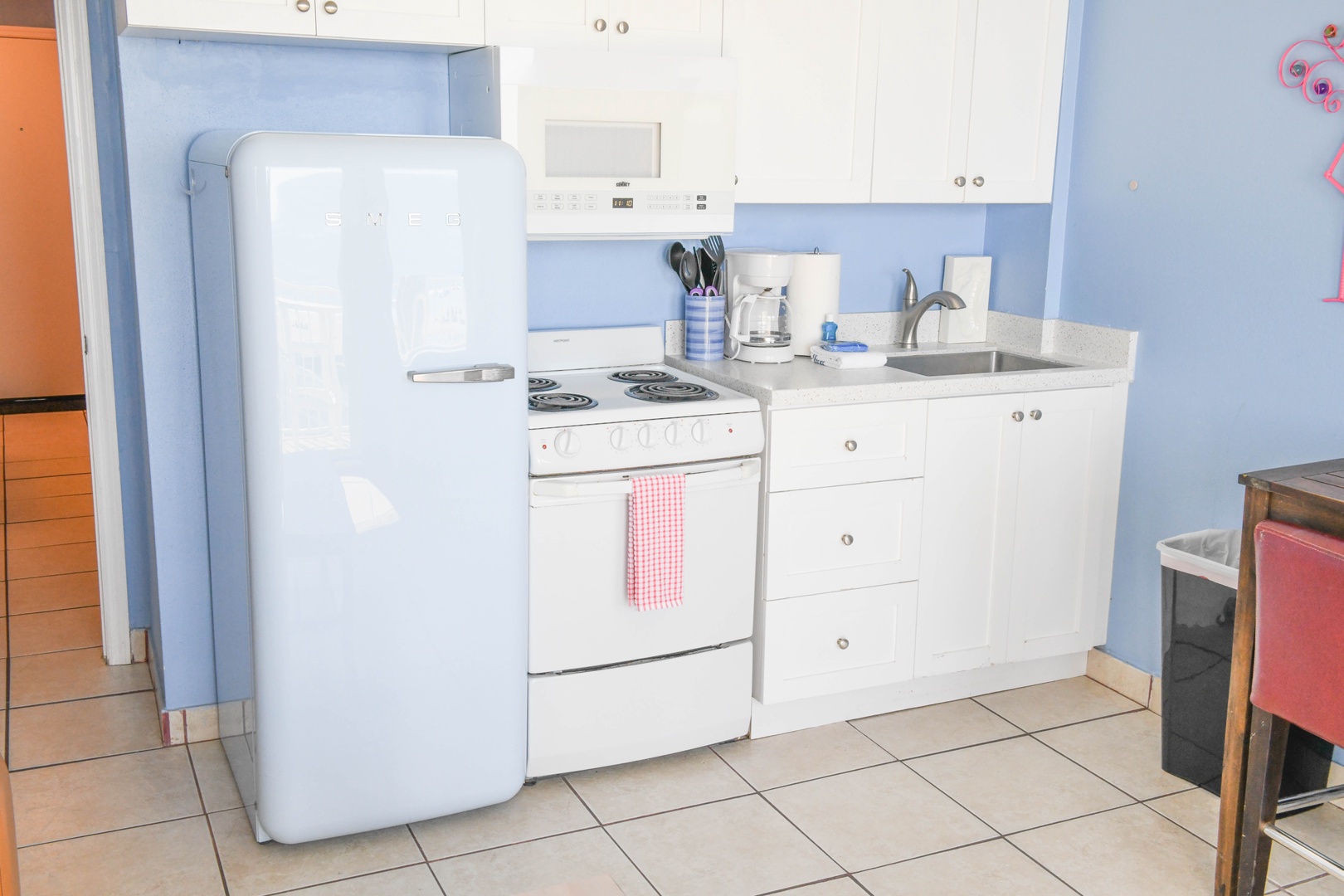 Your fully equipped kitchen awaits with retro-style appliances, stove, sink, and everything you need to prepare meals during your stay.