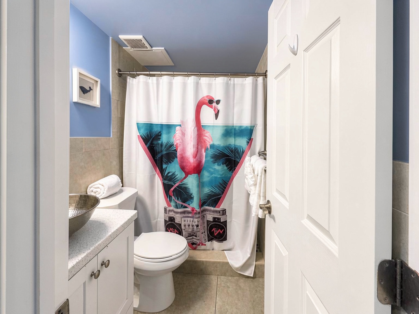 Freshen up in this cheerful bathroom with a fun tropical twist. The spacious shower and well-lit vanity make your morning routine a breeze.