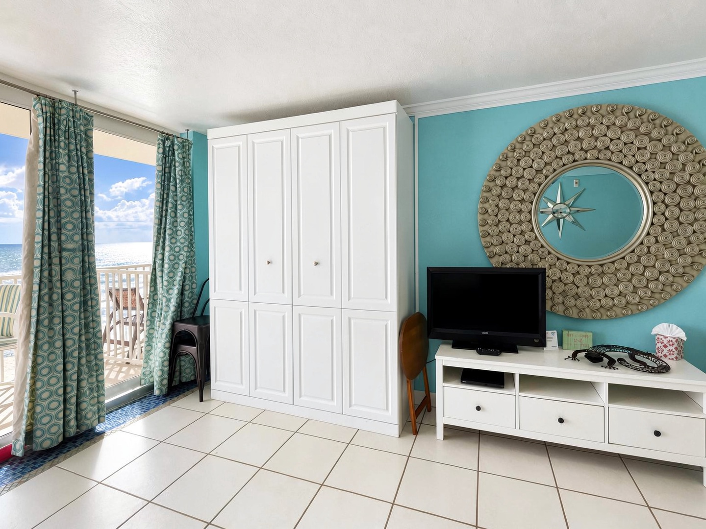 Step into your bright coastal retreat with ocean views framing the living space. The calming turquoise walls and nautical accents set a breezy, beachy tone, while ample storage keeps your vacation essentials tucked away.