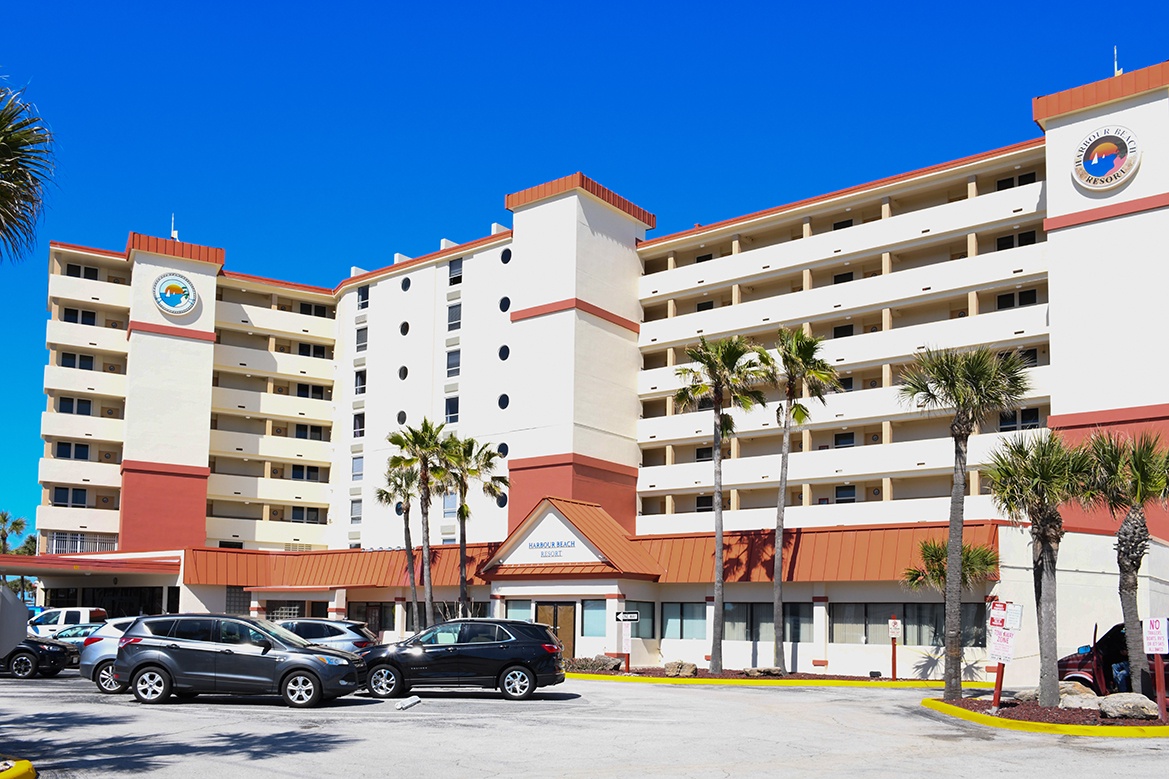 Multi-story beachfront hotel with tropical palm landscaping and convenient parking located steps from your oceanside getaway.