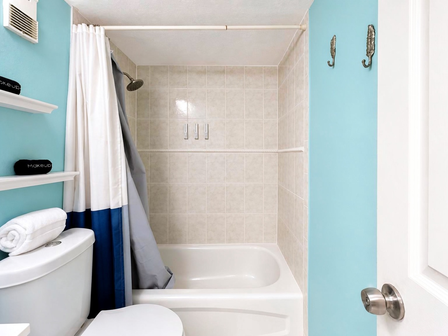 Step into your bright, cheerfully colored bathroom featuring a full tub-shower combo with soothing neutral tile. Fresh towels and thoughtful touches welcome you after a day of adventure.