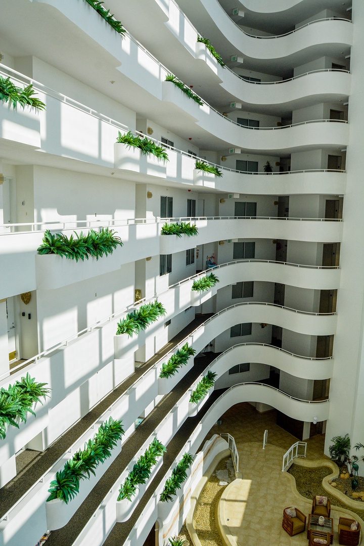 Step into this stunning atrium where cascading greenery lines each curved balcony, creating a peaceful oasis of natural beauty throughout your stay.