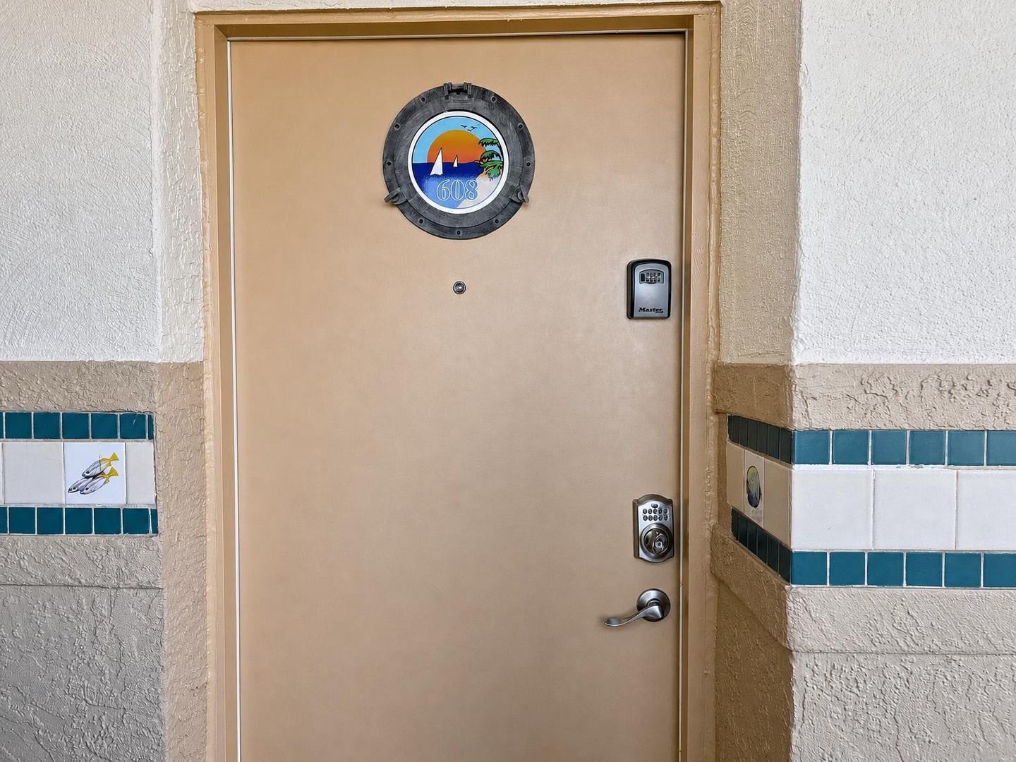A welcoming entrance to your beachside retreat, featuring cheerful coastal decor and convenient keypad access that lets you settle in quickly and start your vacation.
