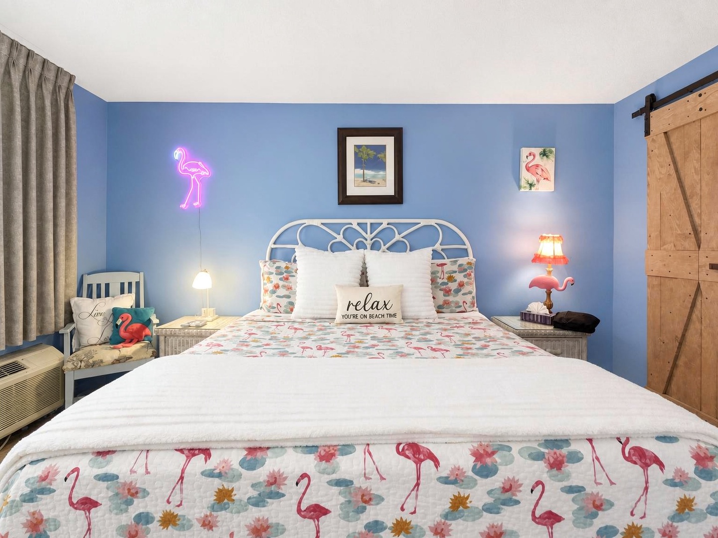 Relax in your beachy retreat with playful flamingo-themed bedding and a glowing neon accent—your cheerful coastal escape awaits.