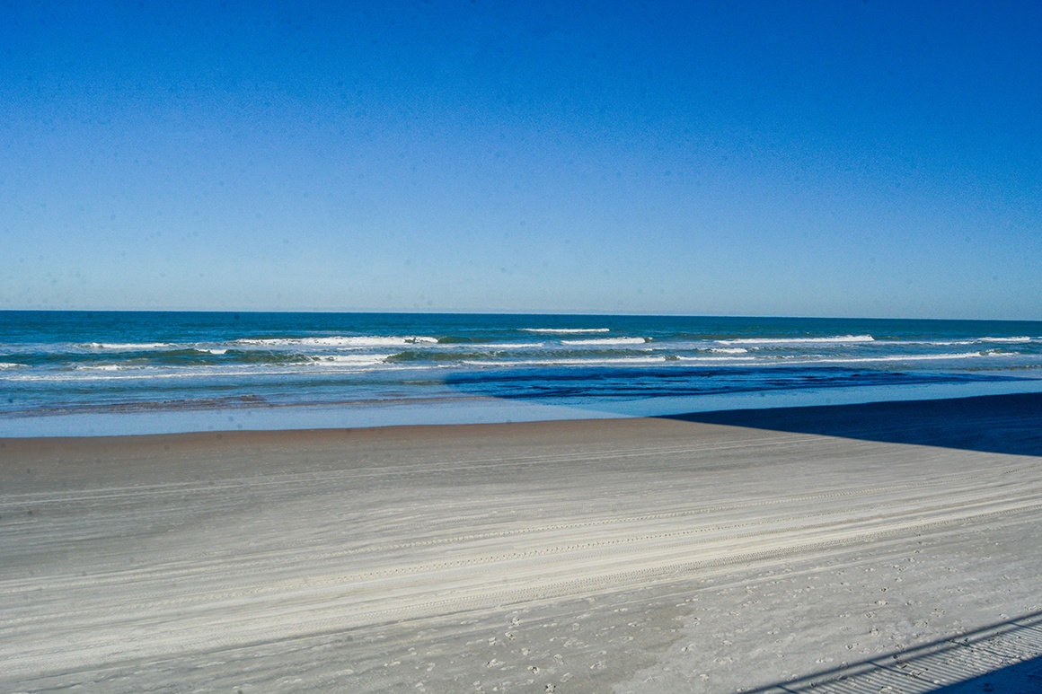 Pristine beach with rolling waves and endless blue horizon stretches along the coastline near the property.