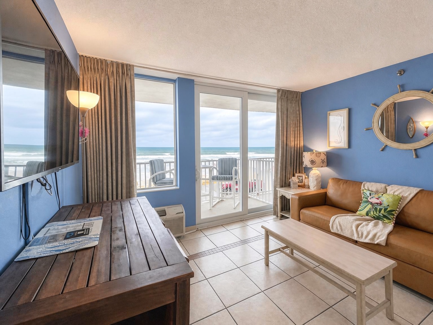 Step into your bright coastal retreat where ocean waves greet you through expansive windows. Sink into the comfortable sofa and let the serene blue tones and nautical accents transport you to pure beachside bliss.