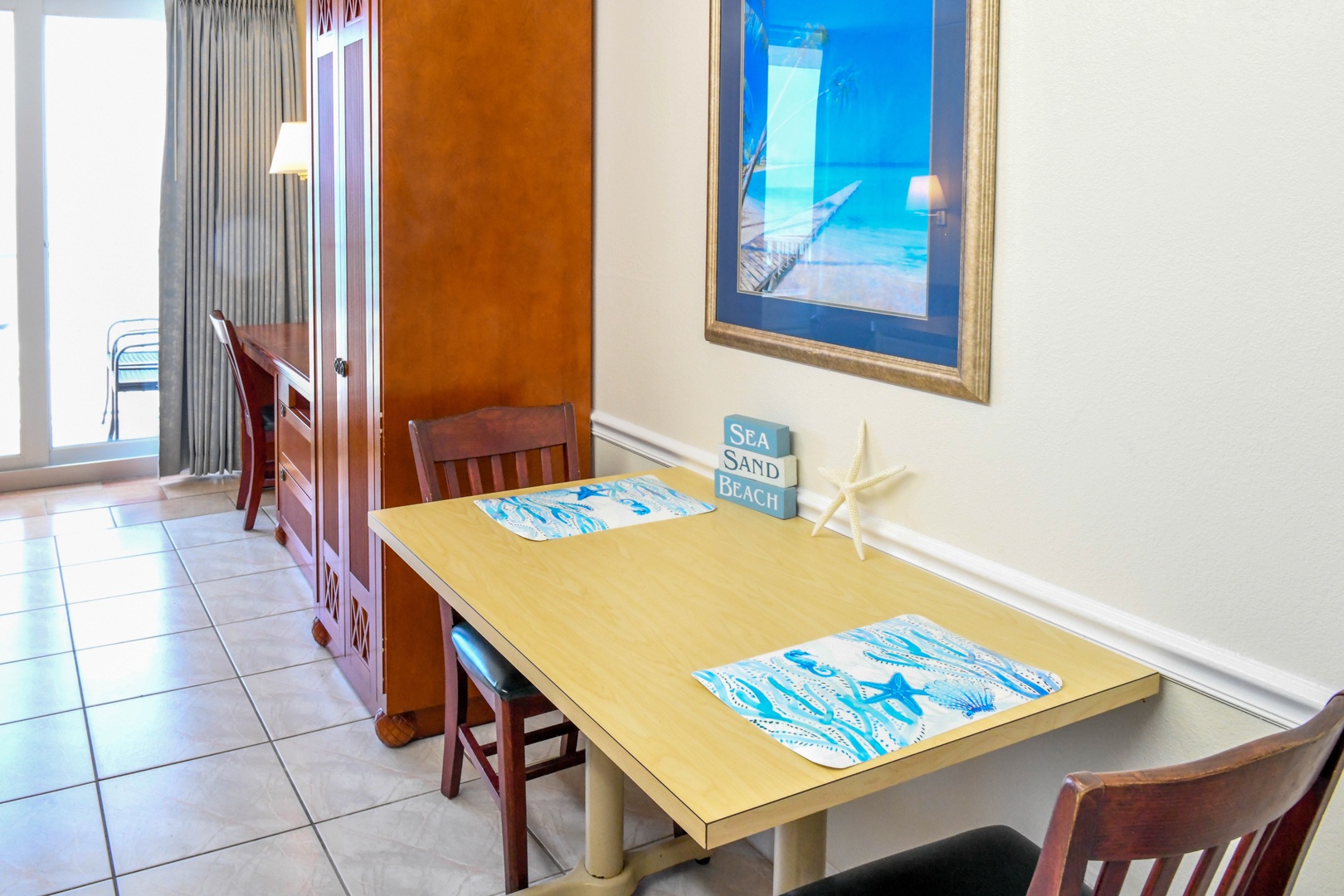 Gather around your beachy dining table for morning coffee or a casual meal. The cheerful coastal décor and natural light create a relaxed, vacation-ready vibe.