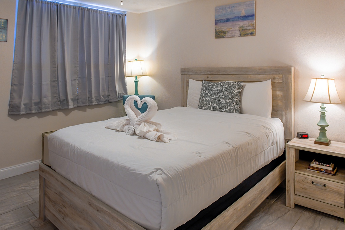 Your peaceful bedroom sanctuary awaits with charming towel swans and soft bedside lighting for ultimate relaxation.