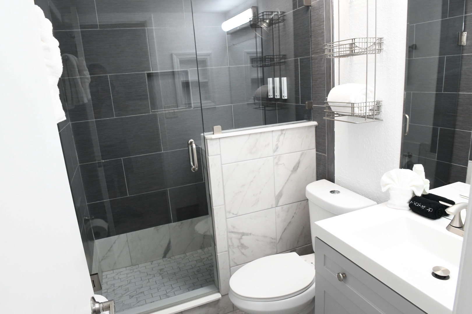Your sleek modern bathroom features elegant marble tiling in the shower, polished fixtures, and plush towels—everything you need to unwind after a day of exploring.