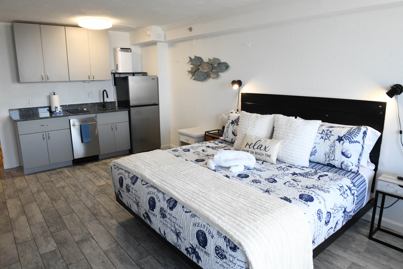 Your cozy beach-themed studio welcomes you with a plush bed dressed in nautical linens, complete kitchenette, and coastal décor that sets the perfect tone for your seaside escape.