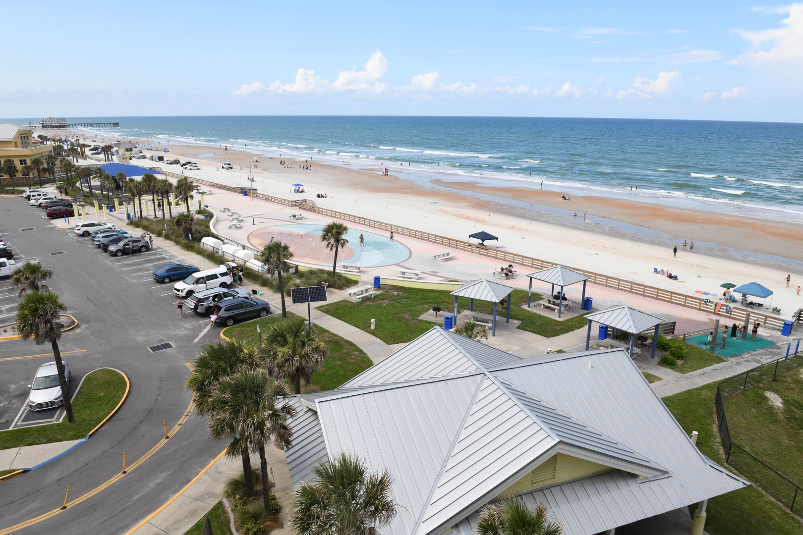 Expansive beachfront location with sandy shores, rolling waves, and convenient public facilities including parking and a nearby pier. The surrounding area offers easy coastal access.
