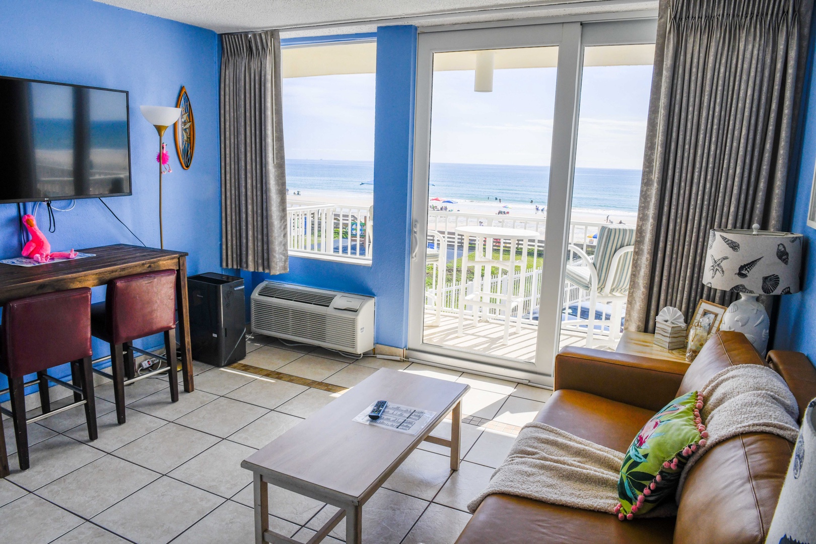 Step into your bright coastal retreat where stunning ocean views await through the sliding glass doors leading to your private balcony—perfect for morning coffee overlooking the beach.