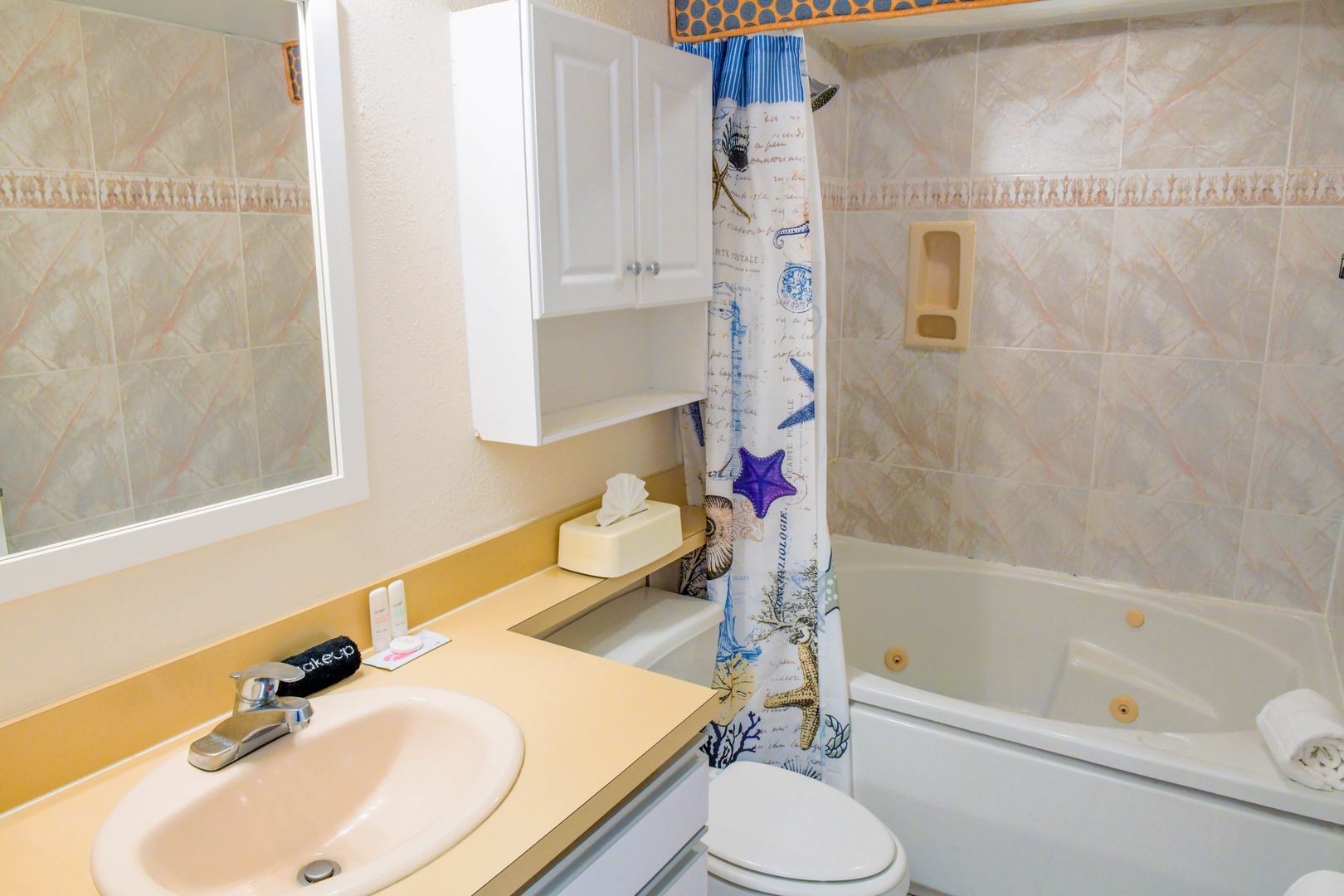 Your private bathroom features a soothing jetted tub perfect for unwinding after exploring, plus all the essentials including a shower-tub combo, fresh towels, and convenient storage.