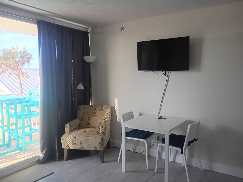 Relax in your bright, modern living space with a flat-screen TV and dining table. Step onto your private balcony to enjoy palm-fringed coastal views.